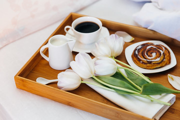 Morning breakfast in tray with coffee and flowers. 