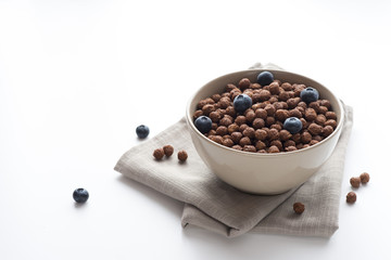 Fototapeta na wymiar Bowl of cocoa cereals on white background