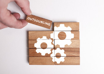 Business, Technology, Internet and network concept. Young businessman shows the word: Outsourcing