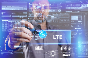Fototapeta premium Business, Technology, Internet and network concept. Young businessman working on a virtual screen of the future and sees the inscription: LTE