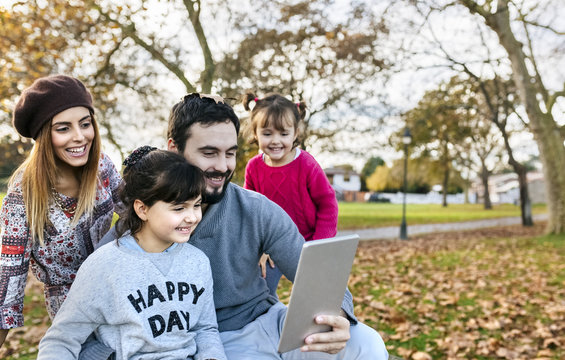 Family with tablet in autumnal park