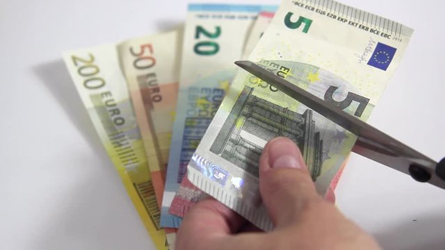 Geld wird mit Schere zerschnitten