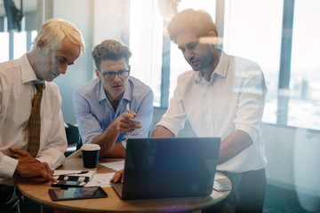 Businessman giving demonstrating on laptop to colleagues