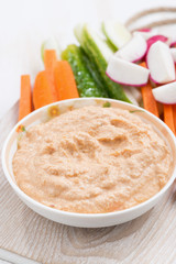 tomato sauce with tofu and fresh vegetables on wooden board, closeup, vertical