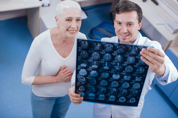 Cheerful nice woman looking at the X ray photo