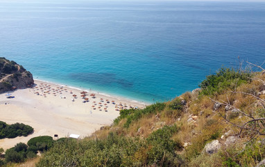 Fototapeta na wymiar Summer Albania beach view. Ionian and Adriatic sea. Seashore with wave sand rock stone sky and sun. Pleasant travel recreation