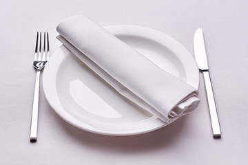Empty served restaurant table with white tablecloth