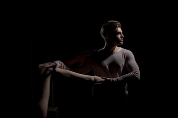 Handsome man posing with sexy naked female leg in hands