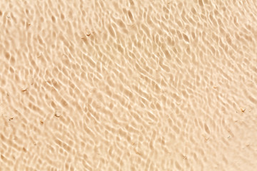 Sand ripples through wave of water, abstract background