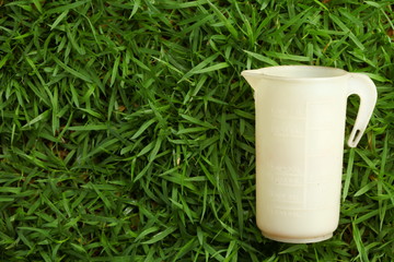 Old oil cup put on the grass floor.