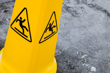 Caution wet floor, yellow warning sign on asphalt