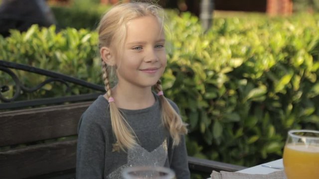 Little girl with two plaits sitting at the table