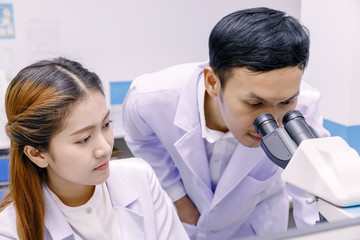 Scientist using a microscope in a laboratory.