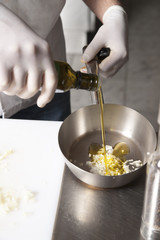 Olive oil is poured into a frying pan