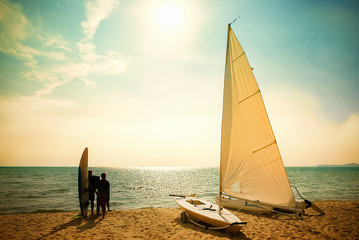 Sailboat on the beach at sunset.