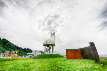 White wind turbine generating electricity around sea.