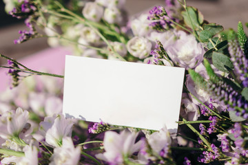Business card mock up with flowers on pink backgroun