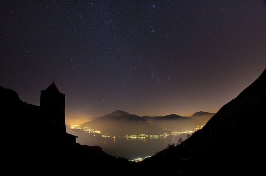 The bell tower of Saint Bernard Church in Musso in a starry night on the Lake Como Lombardy, Italy Europe