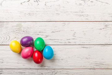 Colorful Easter eggs on white wooden background