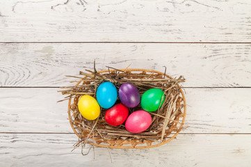 Colorful Easter eggs on white wooden background