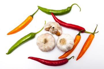 Red, orange and green chili with garlic top view on white background