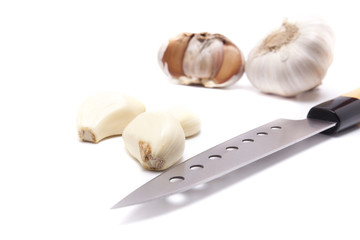 Closeup garlic cloves and knife on white background