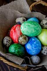 Obraz na płótnie Canvas Colored easter eggs on basket over rustic table.