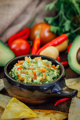 Guacamole with corn chips - nachos, made from avocado, tomatoes and lime.