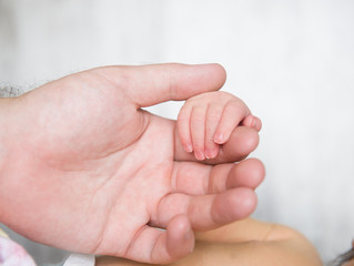 Father holding a newborn baby's hand