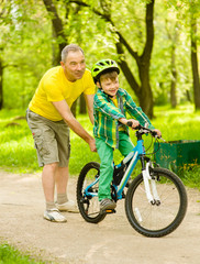 Obraz premium Father teaching his son to ride a bike