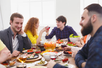 Group of happy people at festive table dinner party
