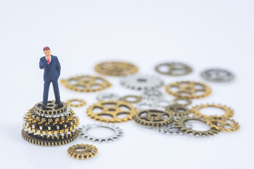 business miniature people standing on stack of metal gear