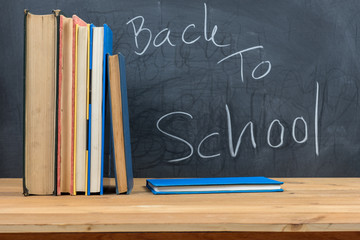 book stack with text back to school on blackboard or chalkboard