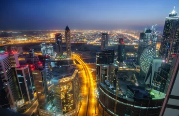 Photo sur Plexiglas moyen-Orient Spectacular aerial view of Dubai, UAE.  Nighttime skyline of a big city at night. Towers of the business bay. Colourful travel background.