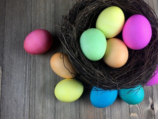 Dyed Easter eggs in a nest on a wood surface