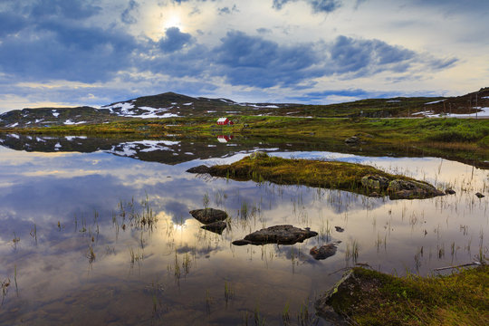 Lonely hut on the berder of a small pond in Handargervidda national park, hordaland, norway
