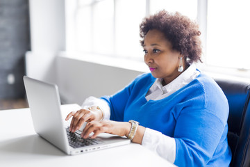Portrait of cheerful business African-American working on laptop