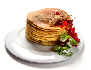pancakes on a white plate with currant jam and berries