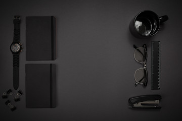 Black objects from the office on a dark gray background. Work an