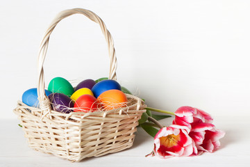 Naklejka premium Colored Easter eggs in a basket