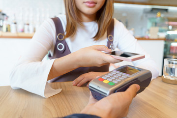 Woman paying money via smartphone with magnetic card concept.