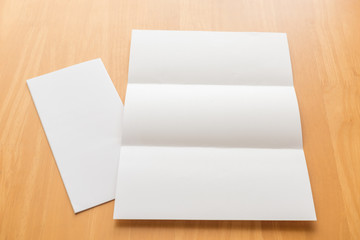 Trifold white template paper on wood background