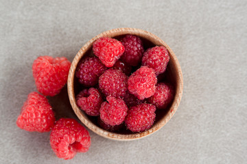 Fresh summer raspberry in a wooden bowl. Top view.