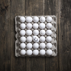 Carton of organic eggs on wooden background.