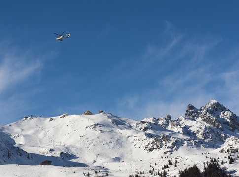 Panoramic view down an alpine mountain valley with helicopter