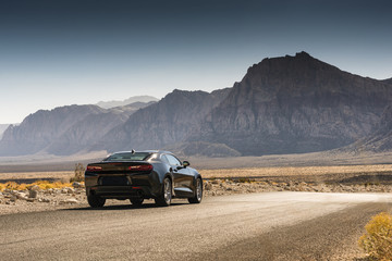 Fototapeta na wymiar Black Sports Car on a Desert Road