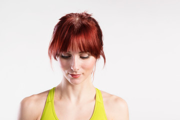 Attractive young fitness woman in green tank top. Studio shot.