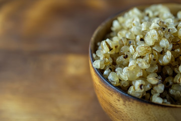 Millet in woodbowl on wood floor with burns.