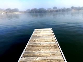 Dock overlooking calm fog on the river
