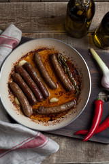 Grilled lamb sausage with rosemary and garlic in a frying pan in olive oil.